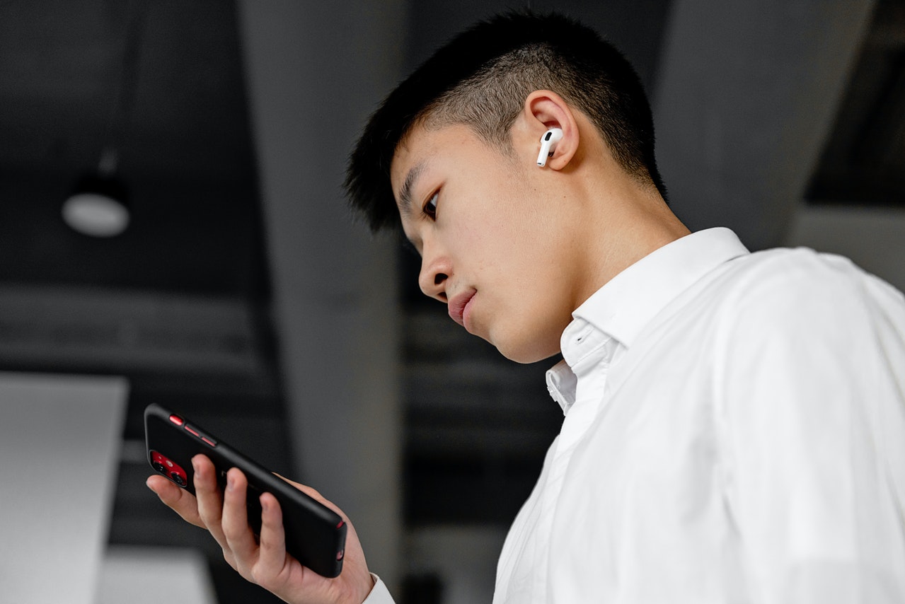 Man is using airpods and listening to siri